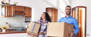 Happy Couple Carrying Boxes Inside House